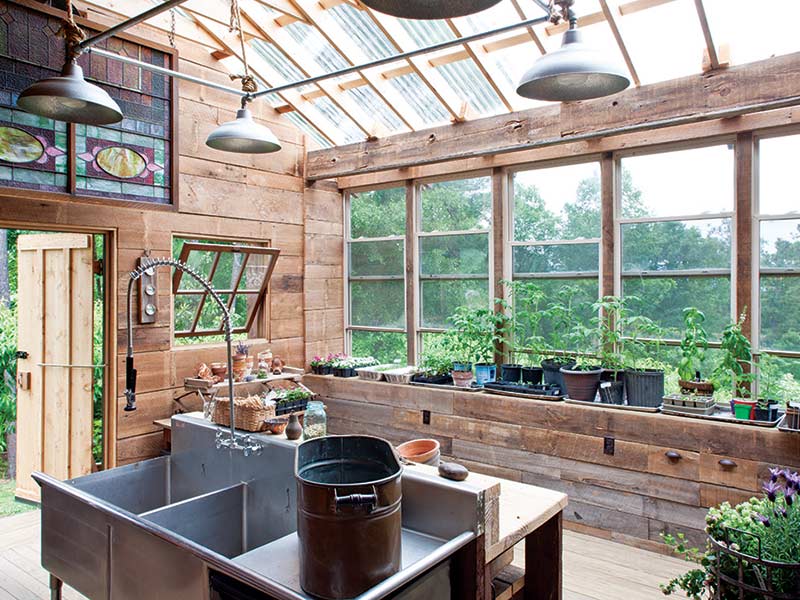A potting shed with wood paneling and large windows.