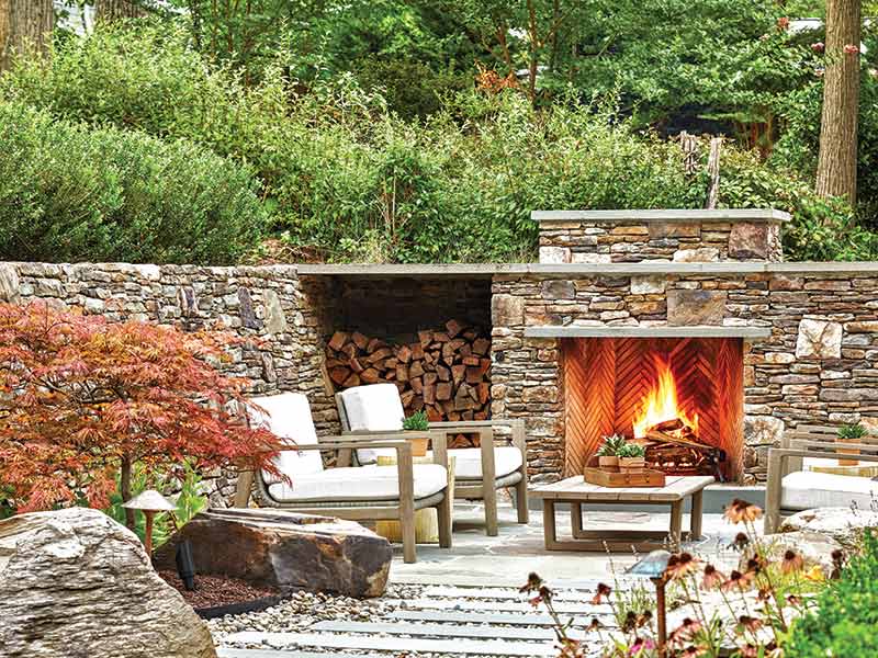 An outdoor seating area with a stone fireplace.