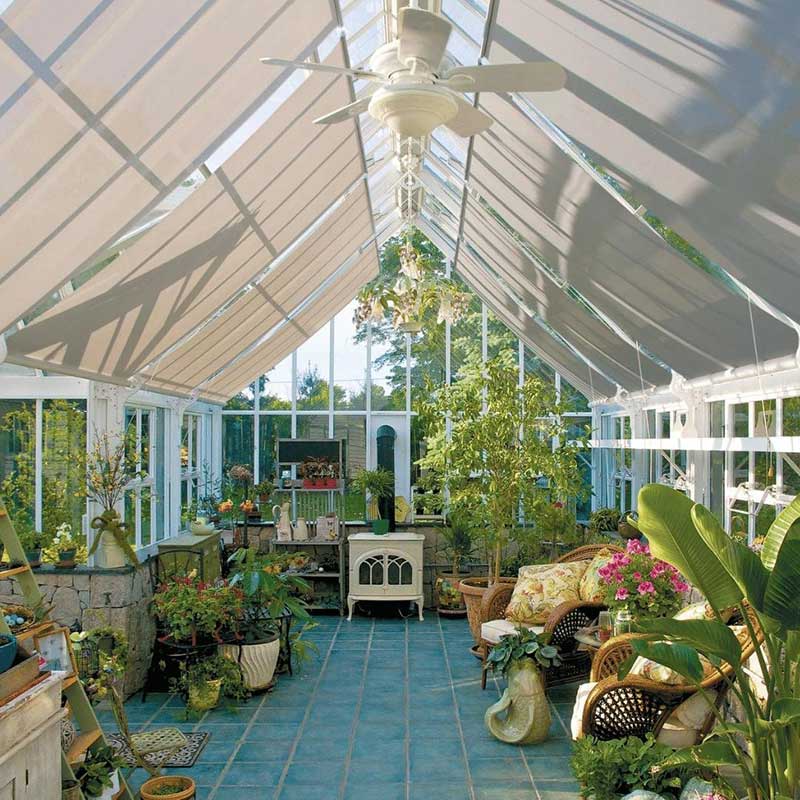 A greenhouse with teal tile floors and an abundance of plants.