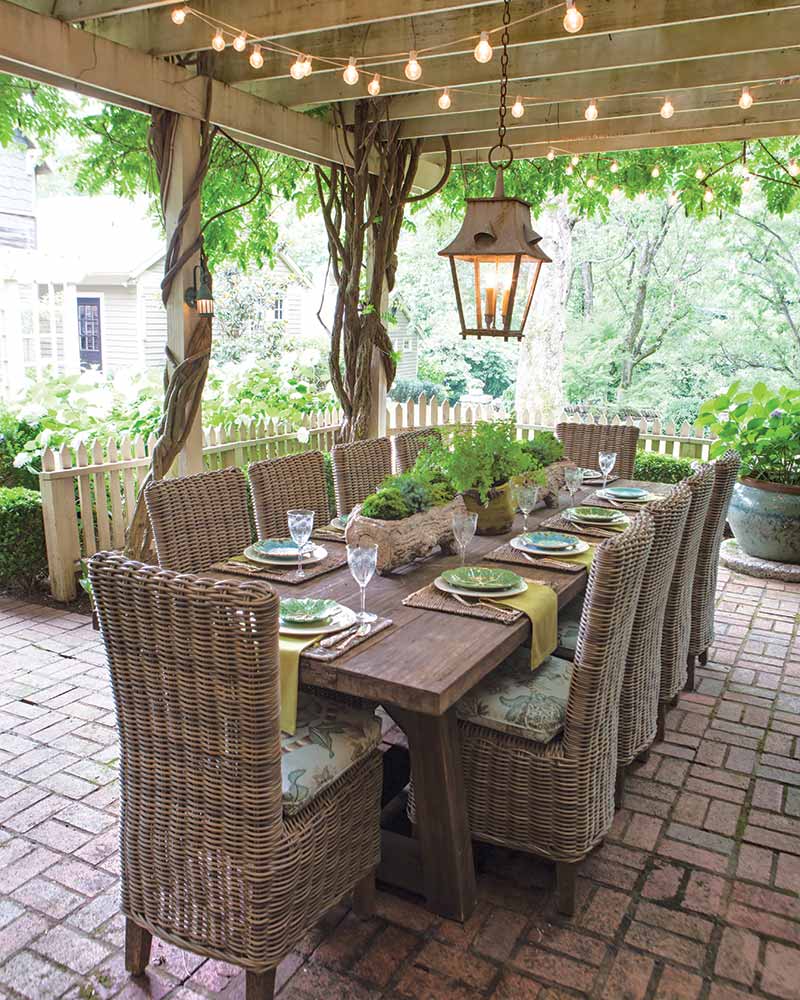 A covered patio with a table set for dinner.