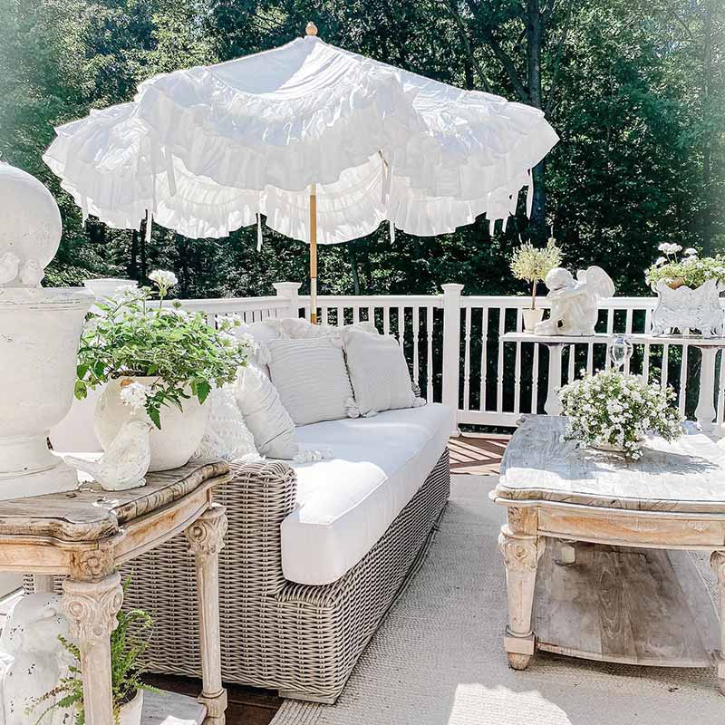 A porch with worn furniture and white accents.