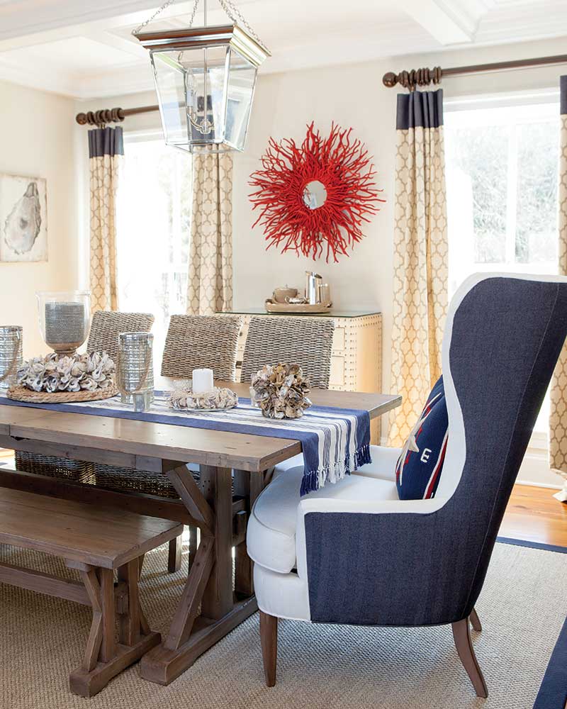 A table with woven side chairs and an upholstered hostess chair.
