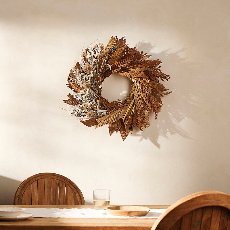 A fall wreath hanging on the wall.