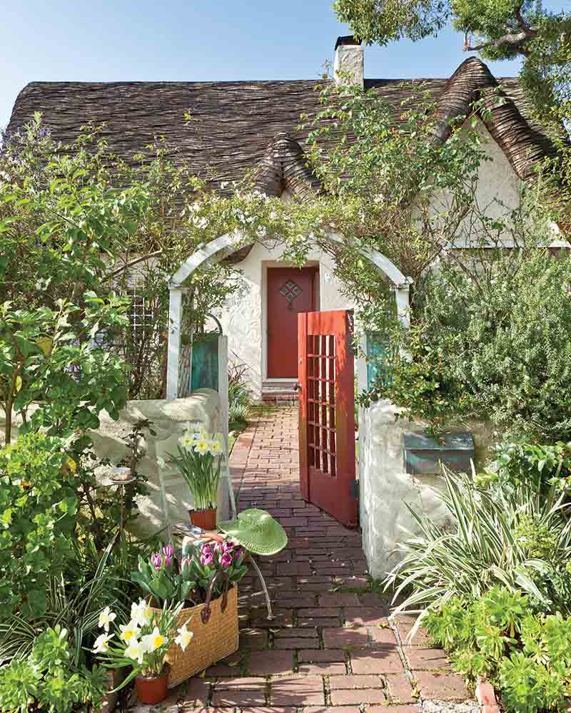 garden gate entry to thatched roof cottage