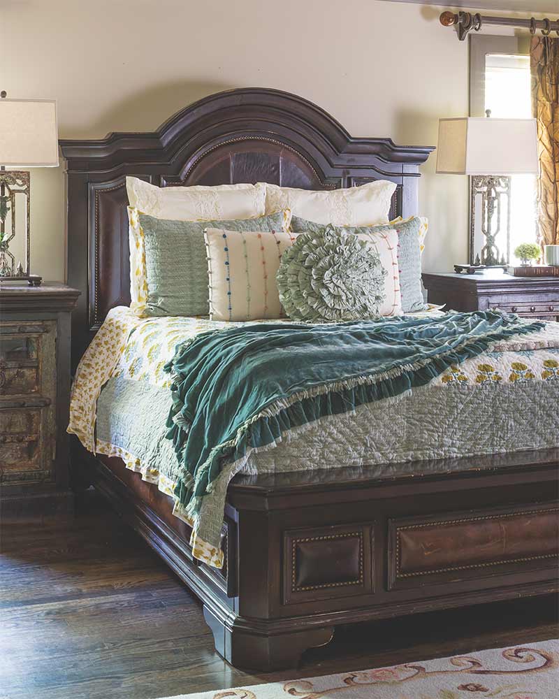 A large bed layered with teal blue linens. 