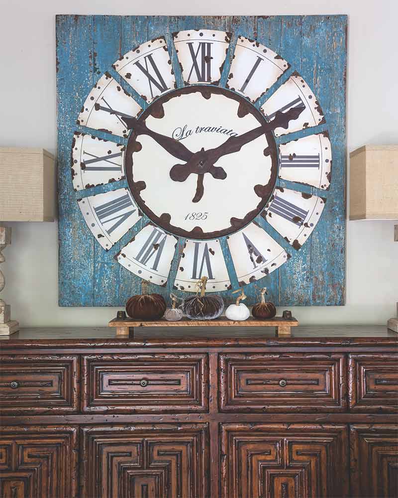 A traditional bamboo style credenza with blue clock-inspired wall art.