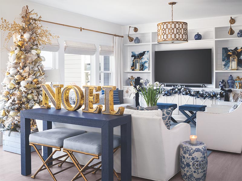 A blue-and-white living room with silver and gold Christmas decorations. 