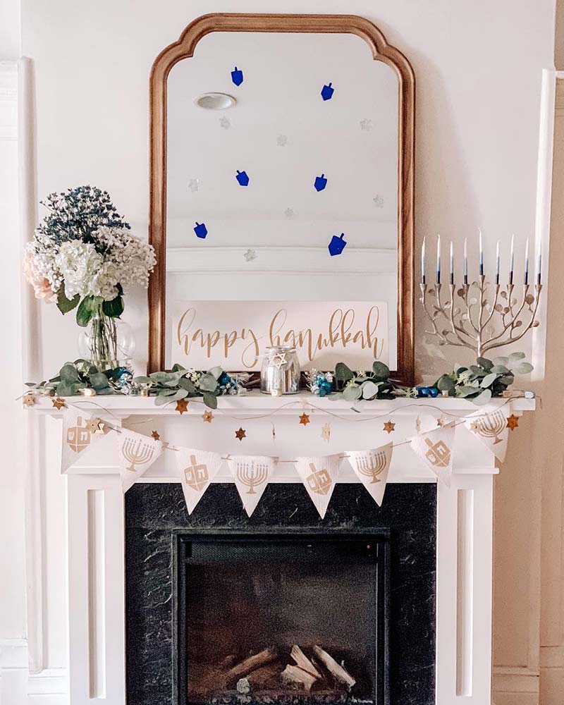 A mantel decorated with pendants and a menorah for Hanukkah. 