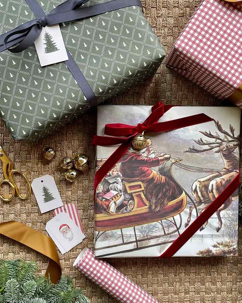 A selection of gift wrap featuring a sleigh scheme, trees, and red-and-white gingham. 