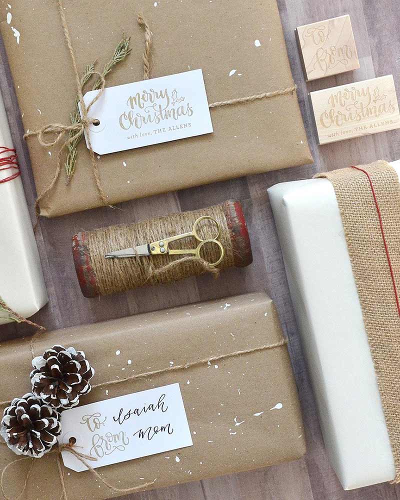 Packages wrapped in Kraft paper and a stamped tag nestled in a twine bow. 