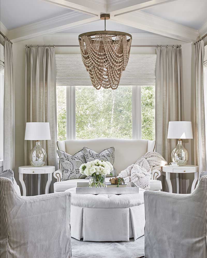 A sunroom decorated in sophisticated white furnishings. 
