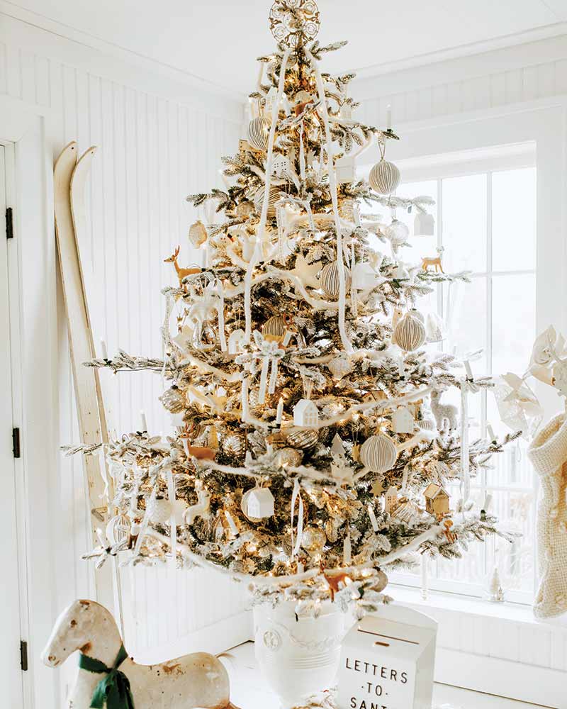 A Christmas tree decorated with white and gold ornaments.