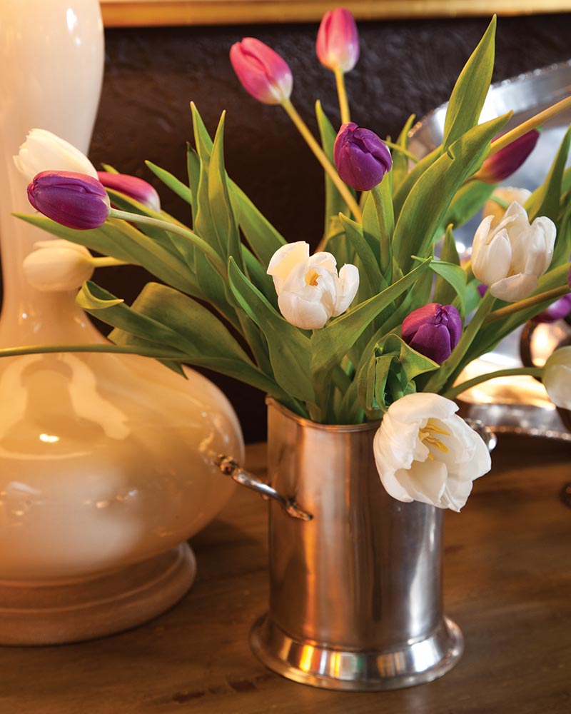 A small silver vase with purple and white tulips.