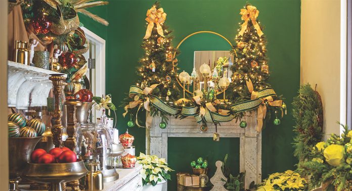 A mantel with a pair of miniature Christmas trees.