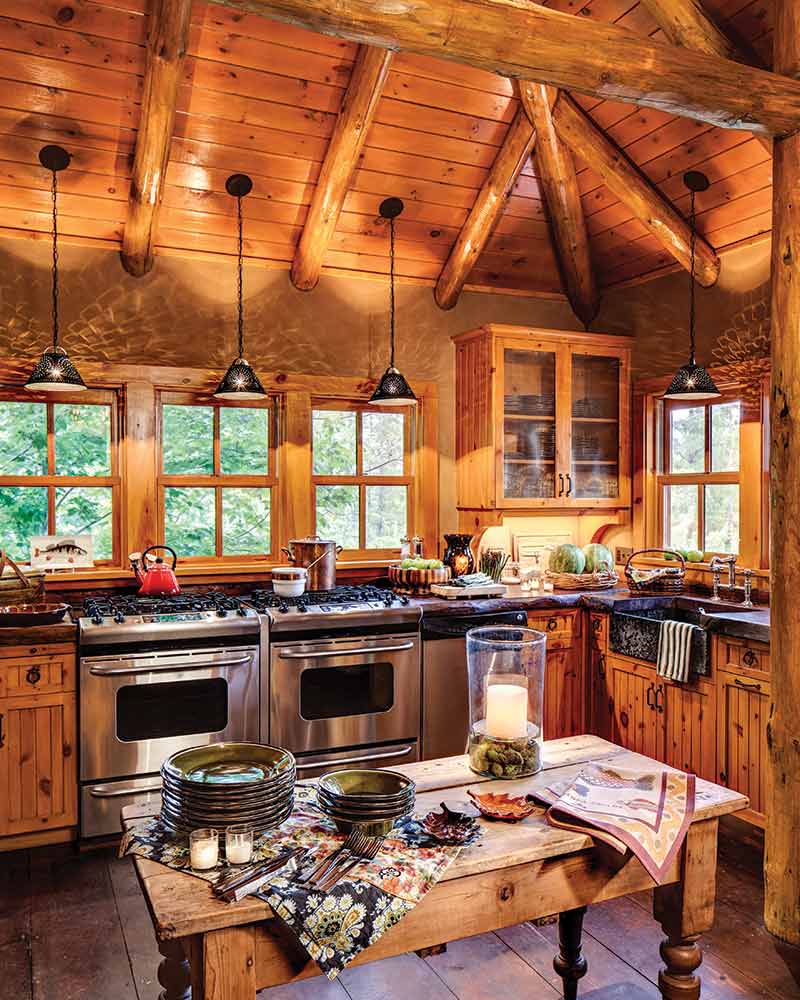 The kitchen in a cabin with a double oven and wood panelling.