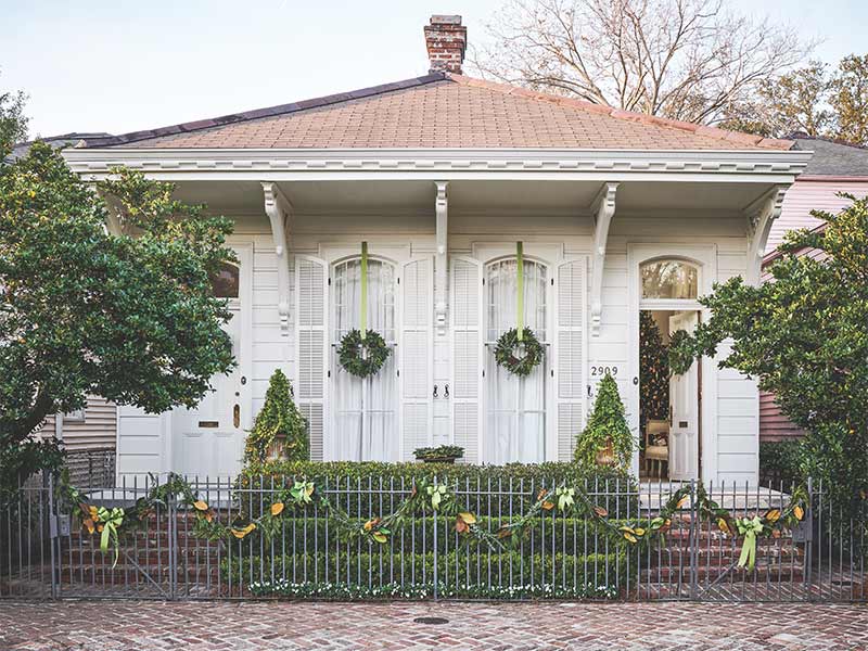 The exterior of a New Orleans Cottage decorated with fresh greenery.