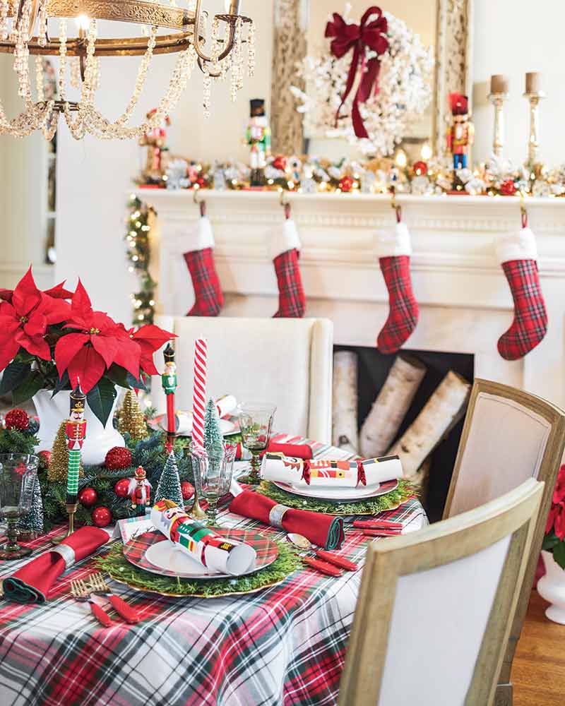 A tablescape set in front of a mantle lined with plaid stockings.