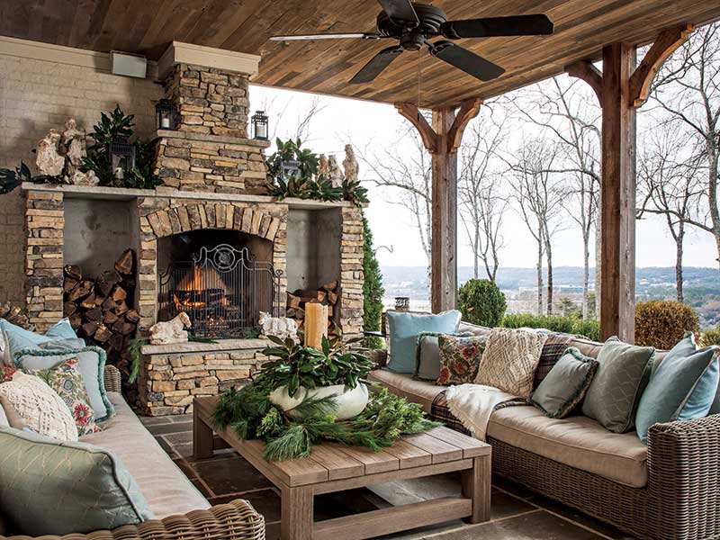 An outdoor fireplace decorated with magnolia leaves.