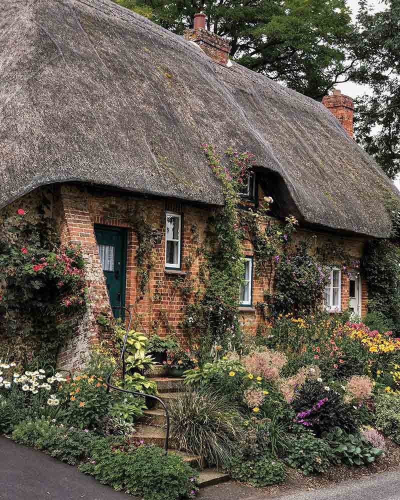 An english cottage with a thatched roof.