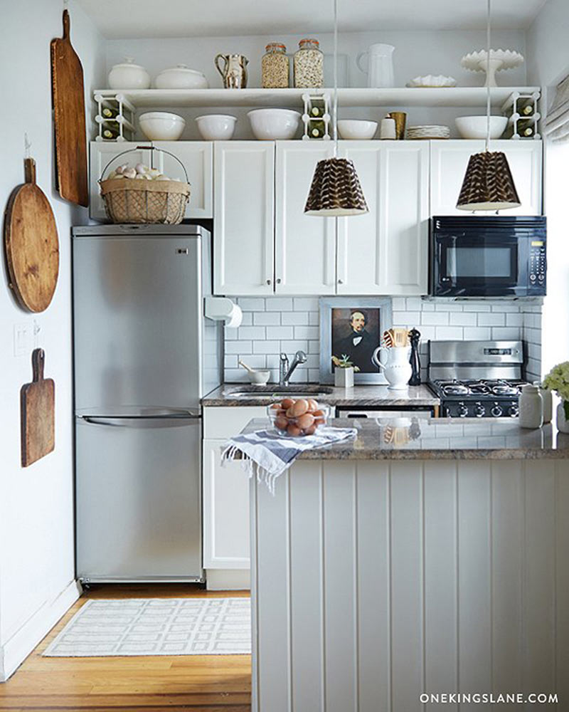 A small white kitchen with extra shelving. 