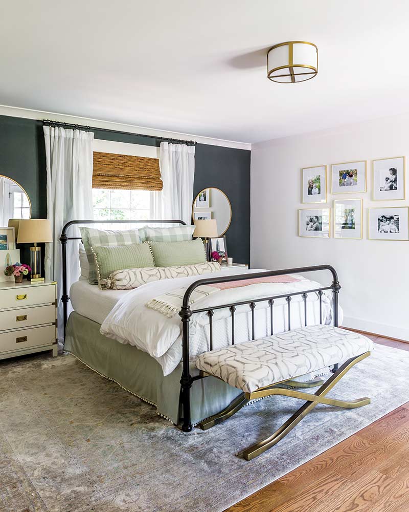 A bedroom with a navy accent wall and a white-and-green bedspread.