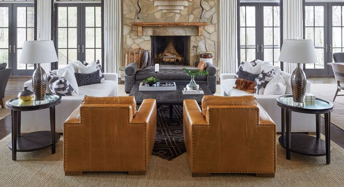 A living room with a stone fireplace and leather furnishings.