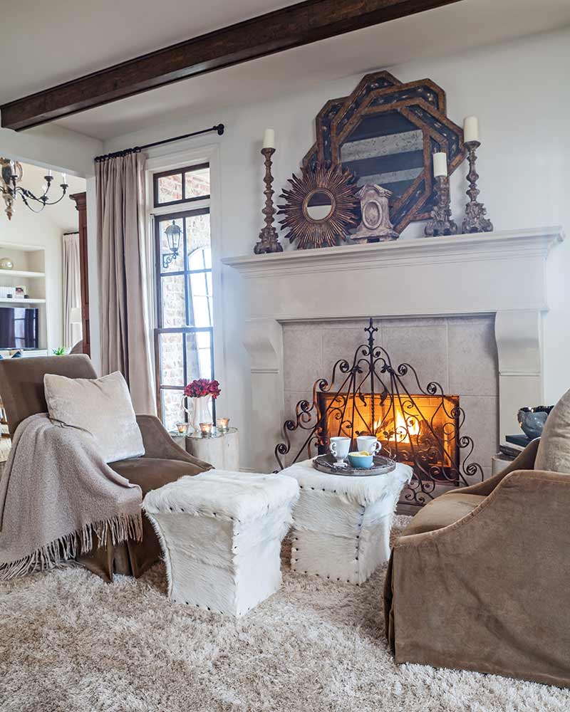 A seating area next to a fireplace with an iron firescreen.