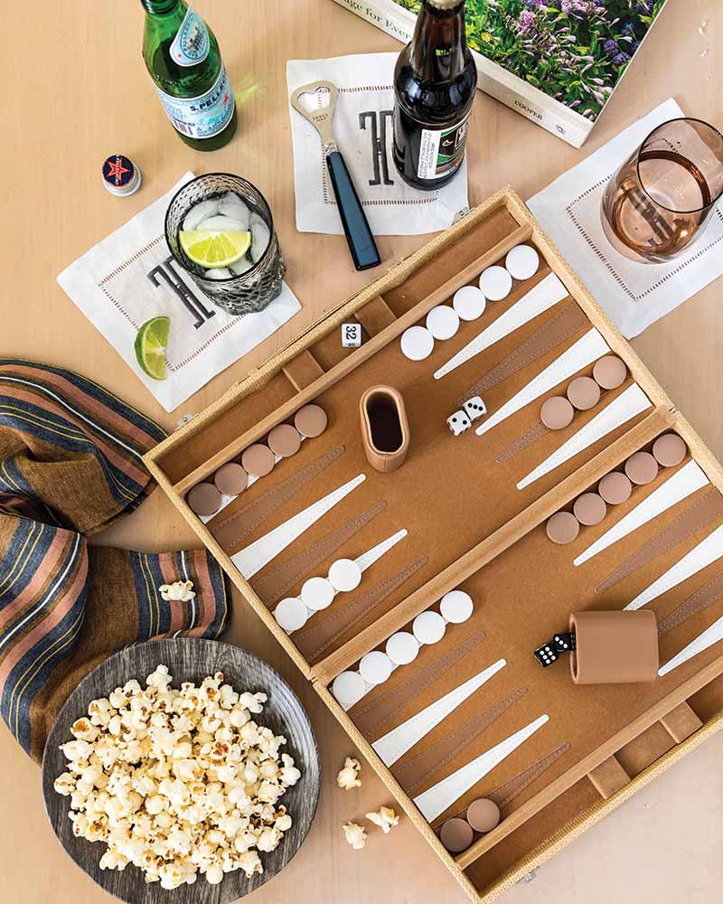 A backgammon game board next to a bowl of popcorn