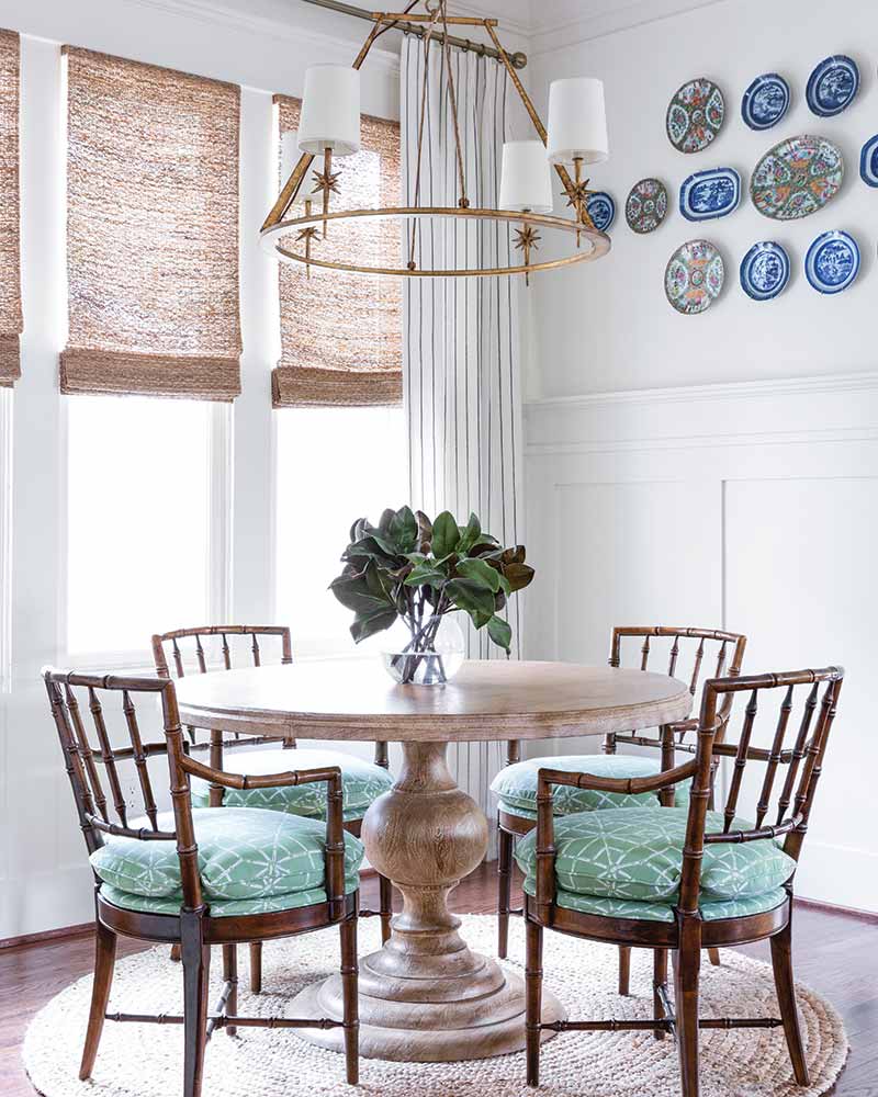 A dining room with a wall display of mix and matched antique porcelain plates.