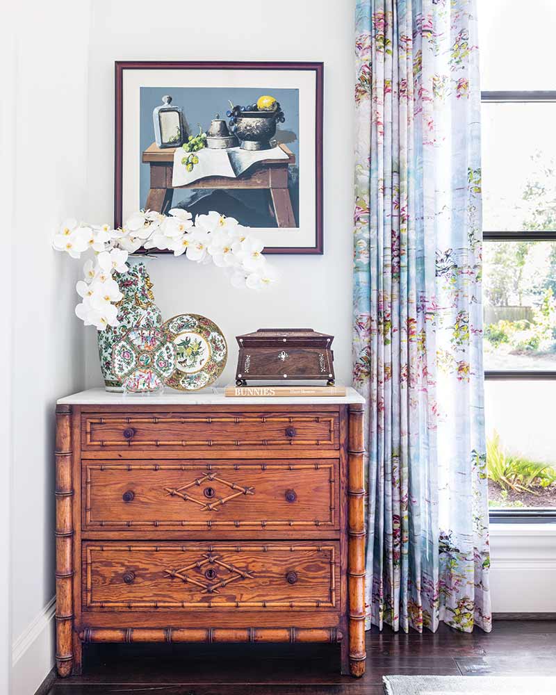 A marble-topped dresser featuring colorful porcelain pieces and an antique wooden box. 