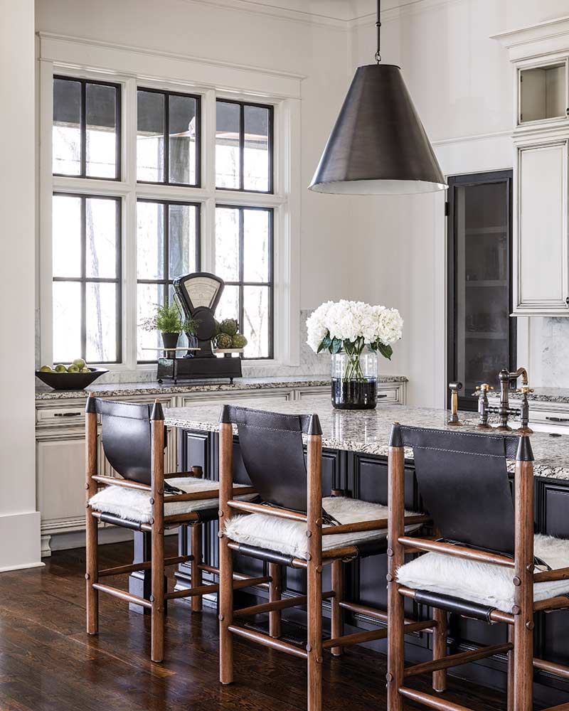 A white kitchen with wood floors and black accents. 