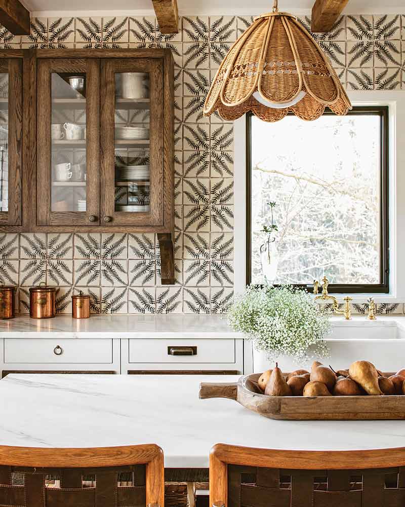 A kitchen with geometric tile and a rattan light fixture.