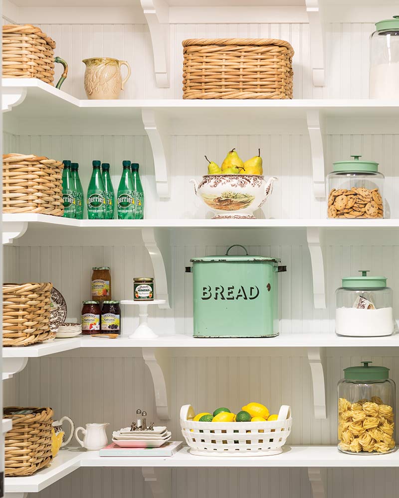 A pantry with glass containers and woven baskets.