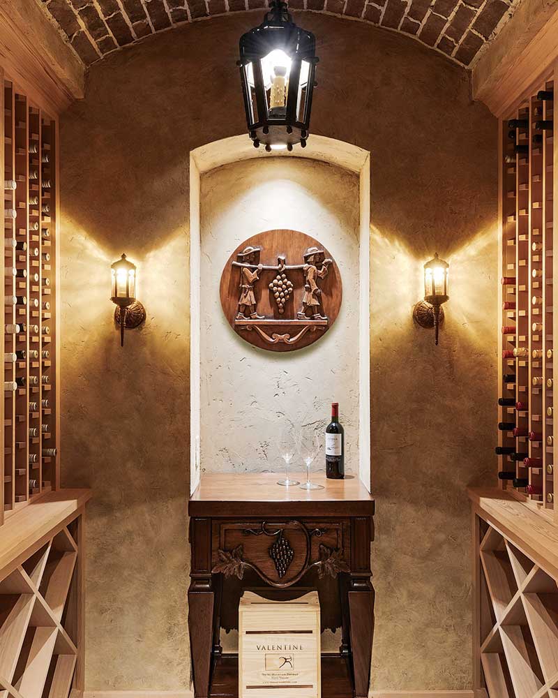 A wine cellar with a carved dresser and wall ornament.
