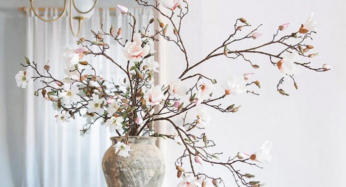 A beige-and-white vase with spring branches.