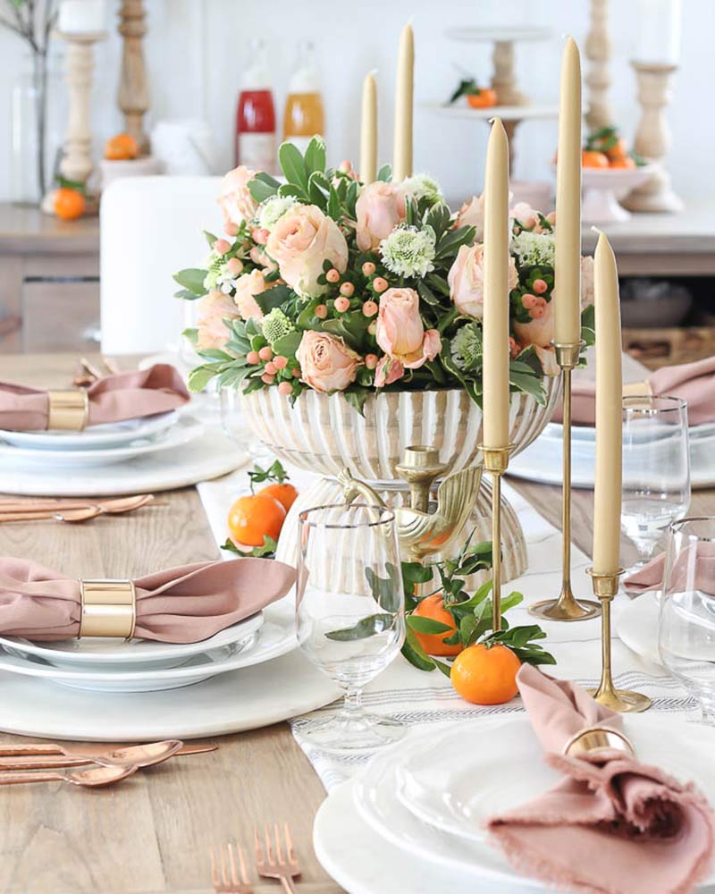 A tablescape with blush linens and florals.
