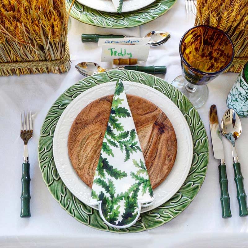 A place setting featuring green bamboo-style flatware.