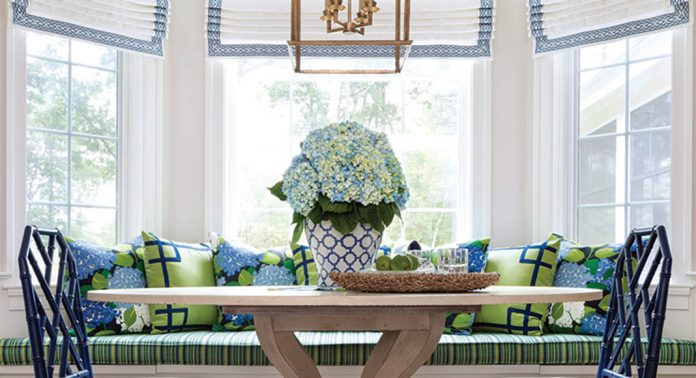 A breakfast nook with a window seat furnished in green and blue.