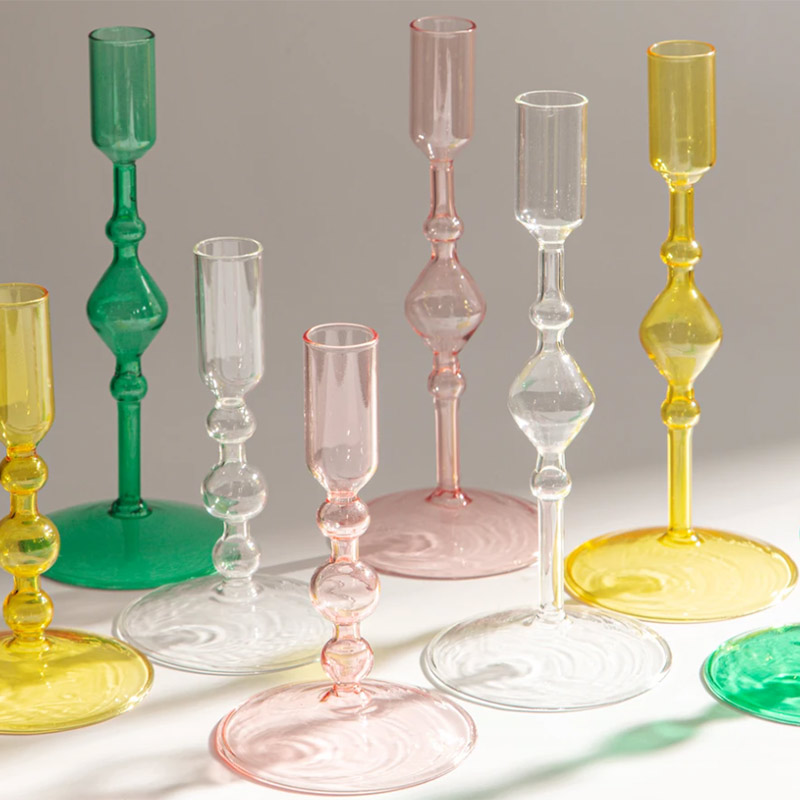 Glass candlesticks in pink, green, yellow, and clear.