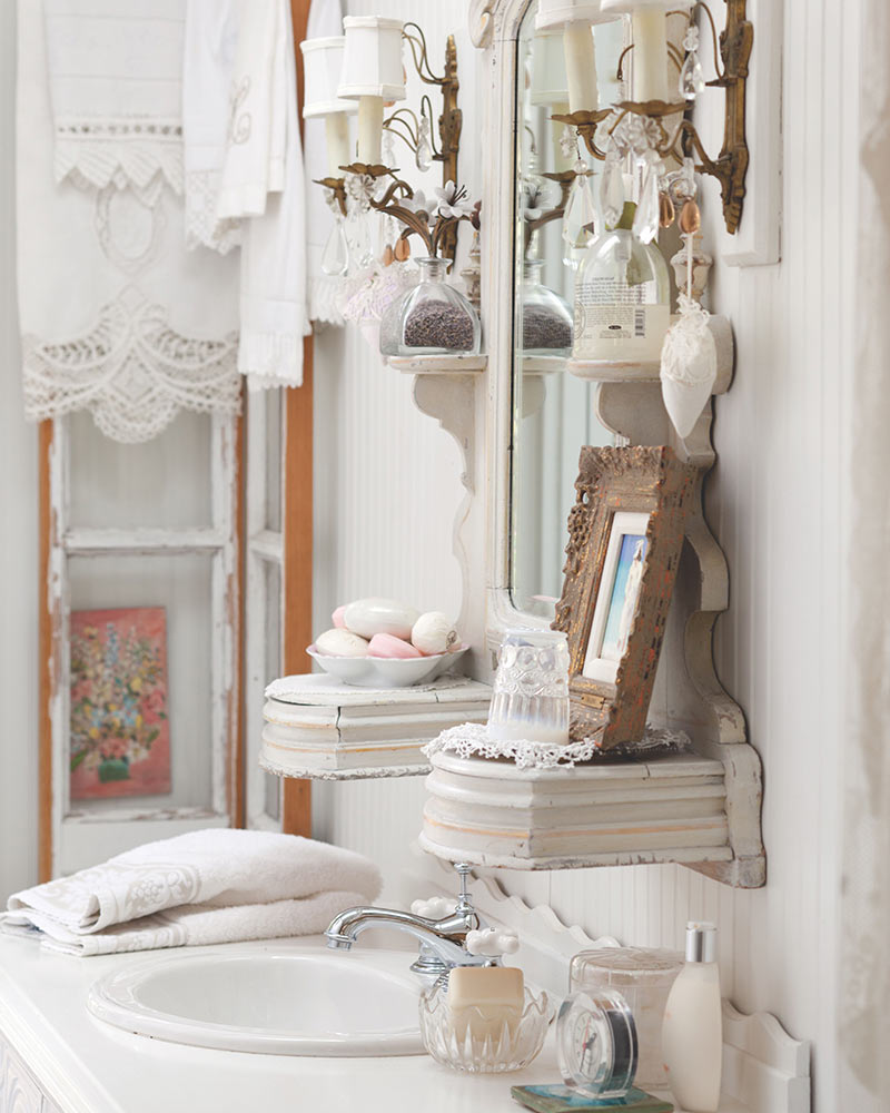A powder room with crystal sconces and heirloom linens.