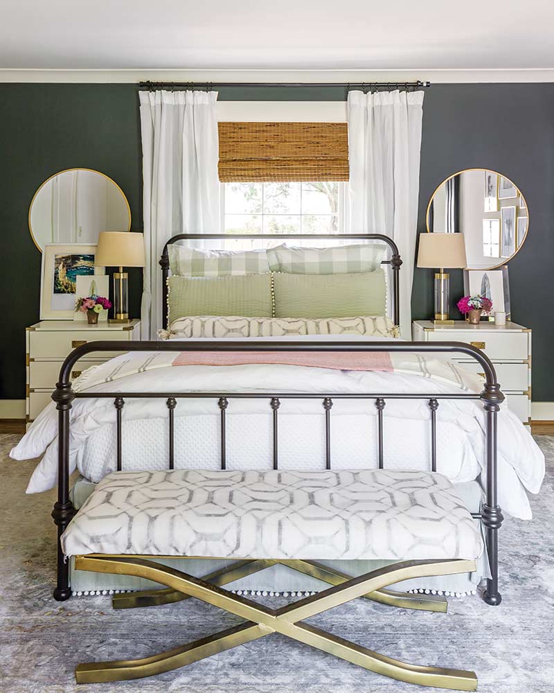 A metal bed with pink and greed bedding.