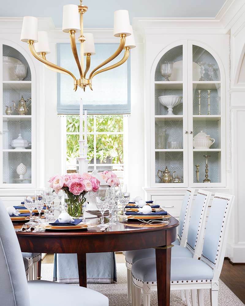 A dining room with a dark wood table and blue-and-white furnishings.