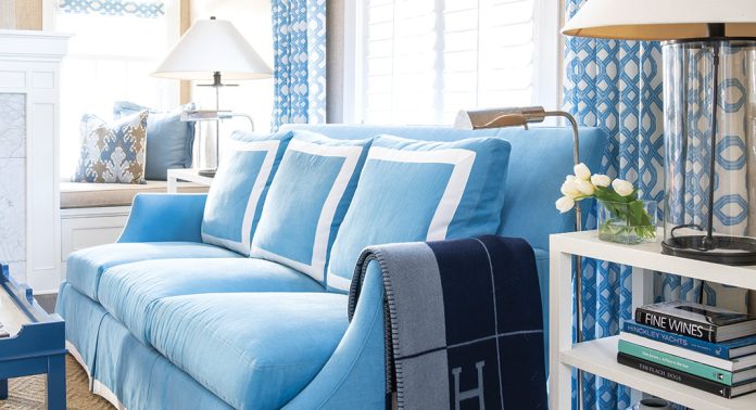 A blue couch with white piping.