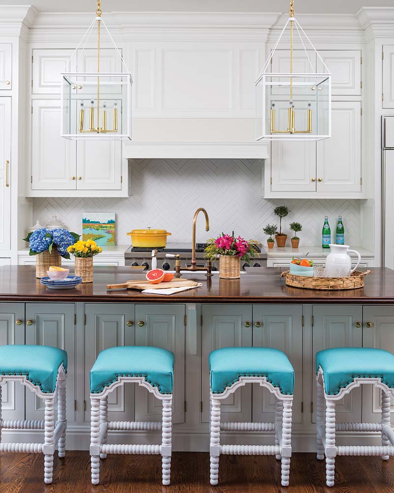 A kitchen island with barstools upholstered with a aqua fabric.