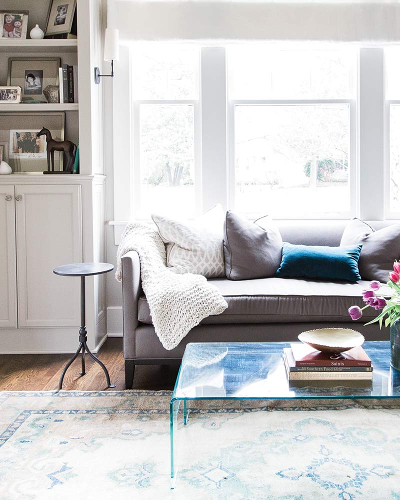 A living room decorated in white, grey, and teal.