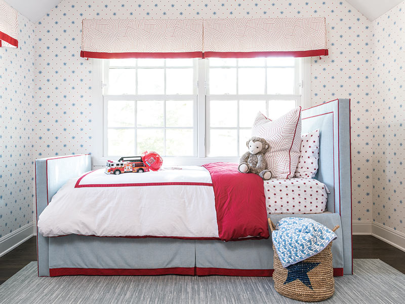 A kids bedroom decorated in red, white, and blue.