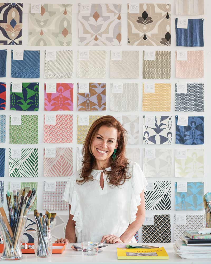 Serena Dugan in front of a wall of fabric samples.