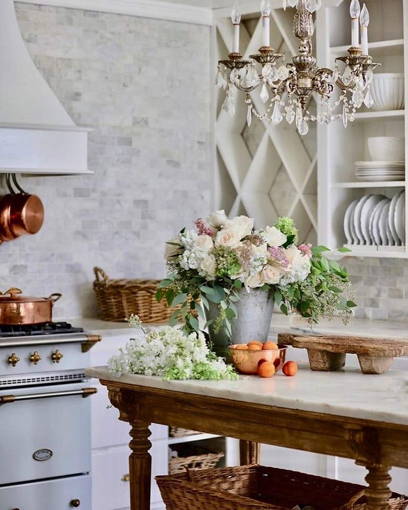 A white kitchen with a crystal chandelier.