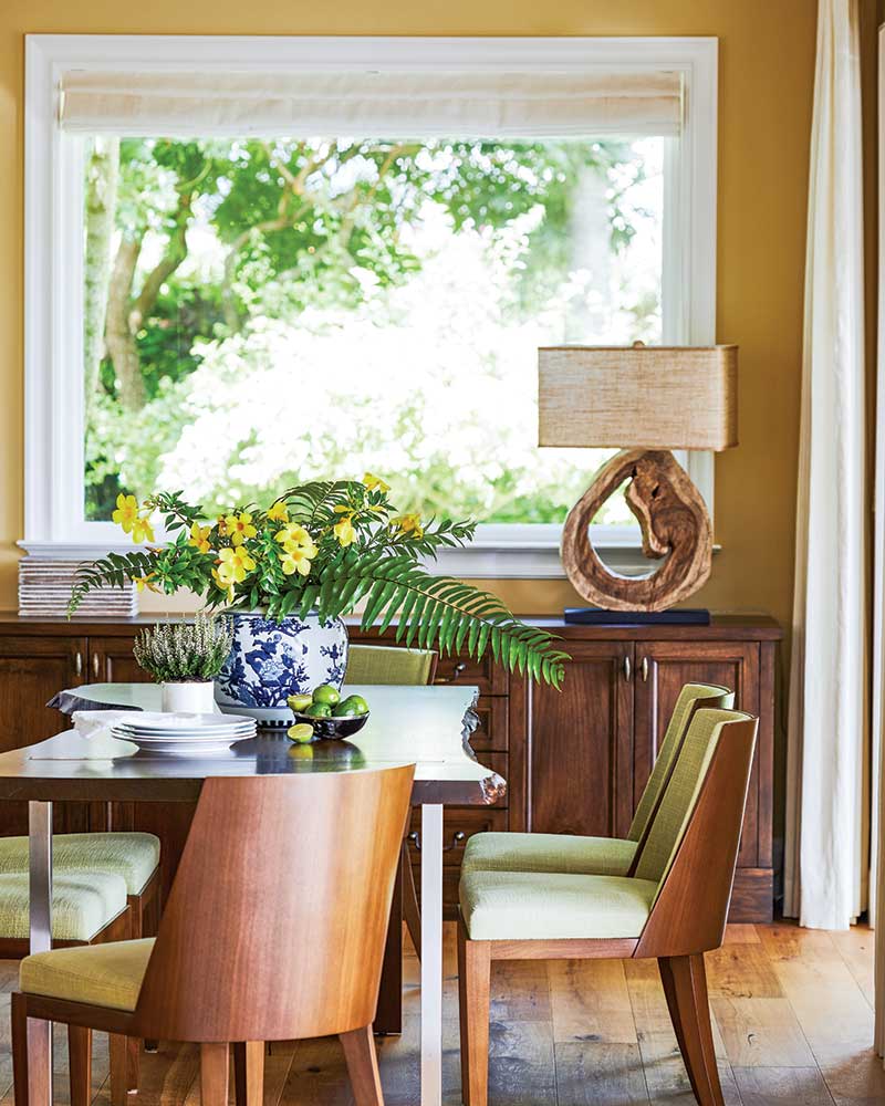 A dining room with a raw-edge wood dining table and wood chairs. 