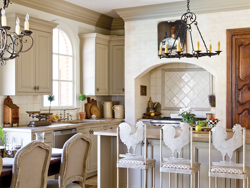 A French country-style kitchen with rooster back bar stools.